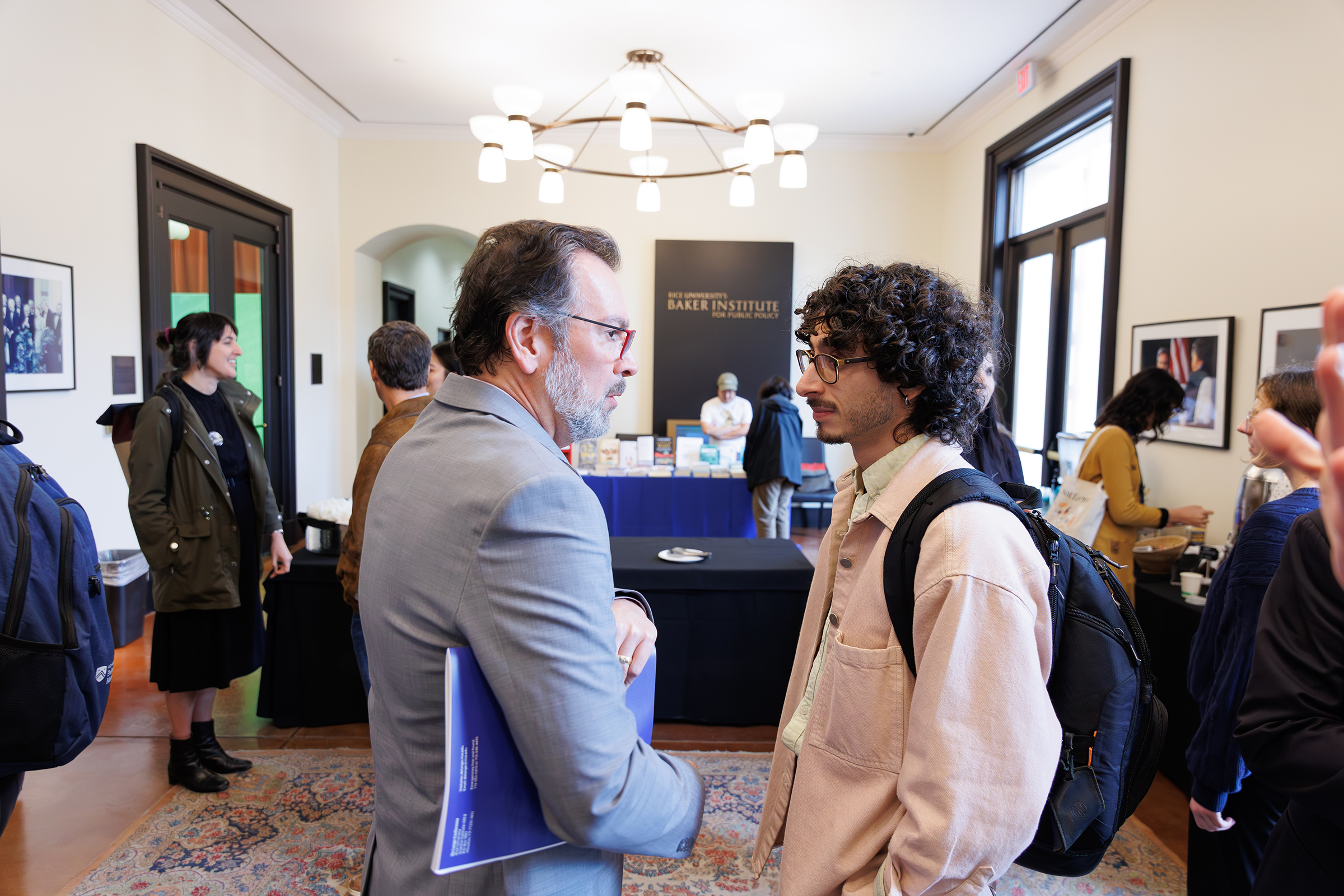 People in conversation at Baker Institute event reception