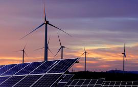 Solar panels in front of wind turbines