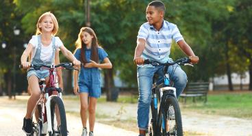  Friends riding bicycles and walking in the park