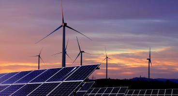 Solar panels in front of wind turbines