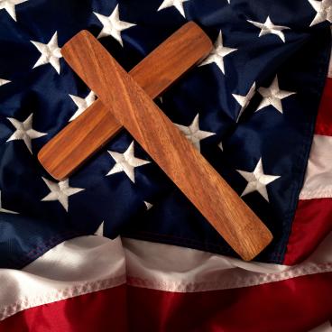  a wooden cross on the american flag