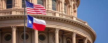 American and Texas state flags and Capitol building